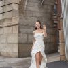 Bridal gown tucked and ruched in all the right places and artfully draped off the shoulder