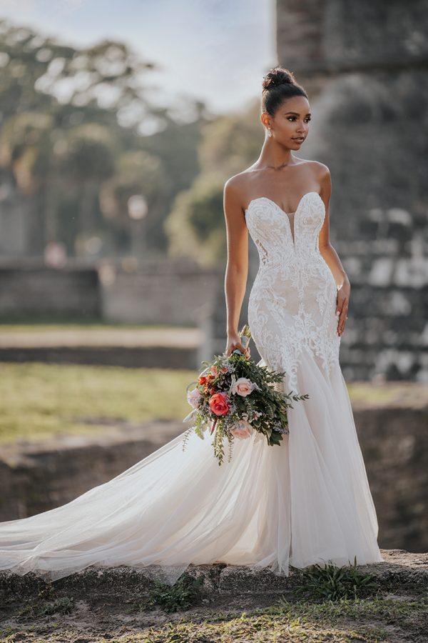 9953 Allure Bridals a Swiss dot pattern, pairs beautifully with the richly beaded and appliquéd strapless bodice of this fit and flare sheath