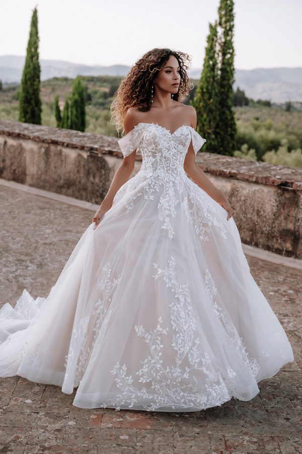 E313 Abella Nasrin gown features off-shoulder sleeves and trailing lacy vines across the bodice and hem